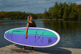 woman carrying a Cruiser SUP® stand up paddle board - Xcursion Classic
