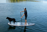 man stand up paddle boarding with his pup on Cruiser SUP® Bliss LE on a lake