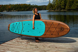 woman carrying a Cruiser SUP® stand up paddle board - Xplorer Woody