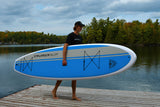 man carrying a Cruiser SUP® stand up paddle board - Xcursion Classic